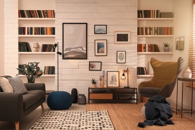 Cozy home library interior with comfortable furniture and collection of different books on shelves