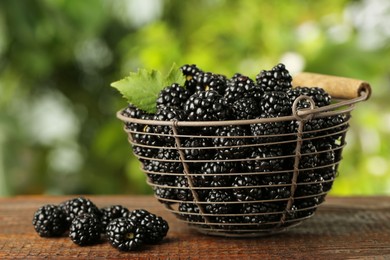 Photo of Basket of fresh ripe blackberries on wooden table outdoors, closeup