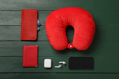 Photo of Flat lay composition with red travel pillow and smartphone on green wooden background