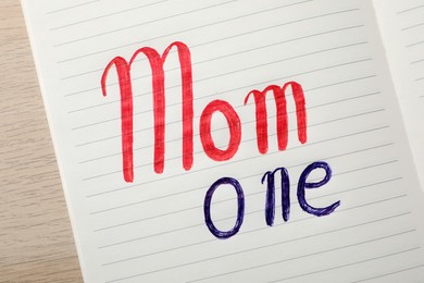 Photo of Being single mother concept. Notepad with text Mom One on white wooden table, top view