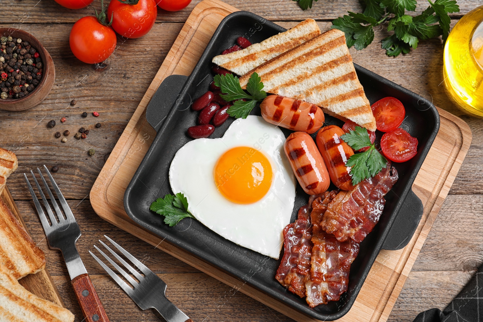 Photo of Delicious breakfast with heart shaped fried egg and  sausages served on wooden table, flat lay