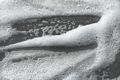 White washing foam on dark gray background, top view