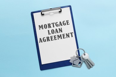 Image of Mortgage loan agreement with Approved stamp and house keys on light blue background, top view