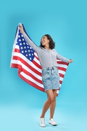 Photo of happy young woman with USA flag on blue background