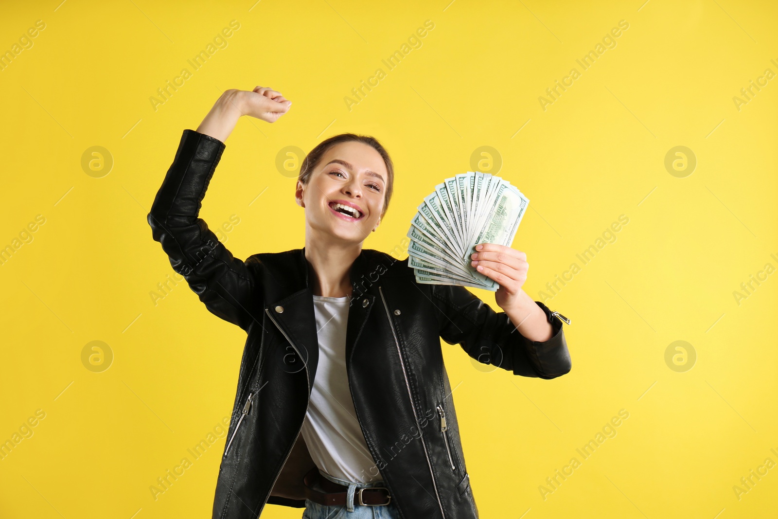 Photo of Emotional young woman with money on yellow background