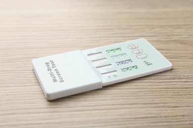 Multi-drug screen test on light wooden table, closeup