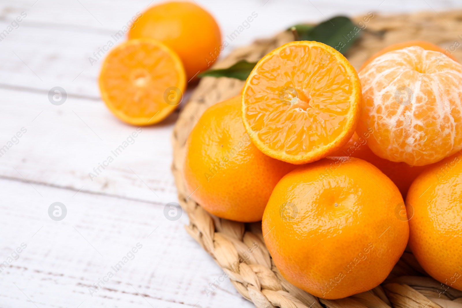 Photo of Fresh juicy tangerines on white wooden table, space for text