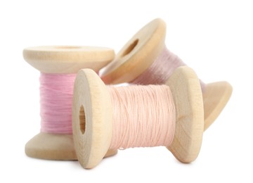 Photo of Different colorful sewing threads on white background, closeup