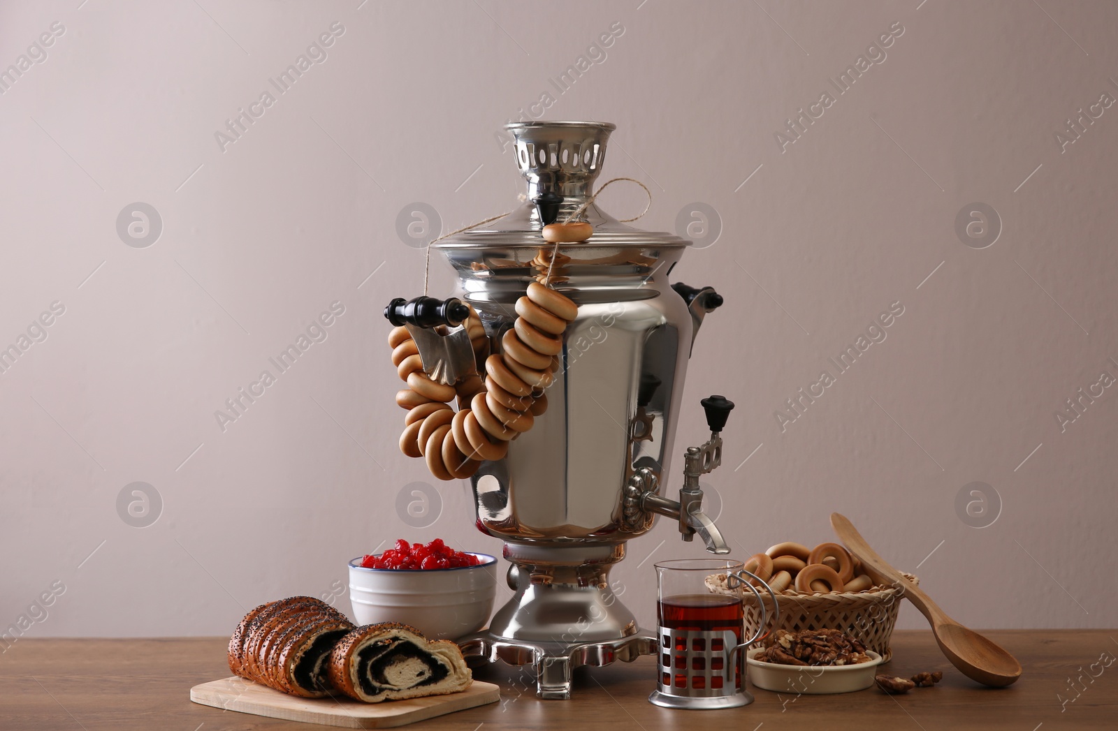 Photo of Traditional Russian samovar with treats on wooden table