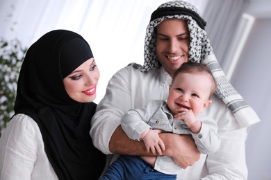 Photo of Happy Muslim family with little son indoors