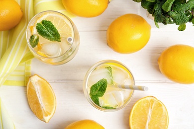 Photo of Cool freshly made lemonade and fruits on white wooden table, flat lay