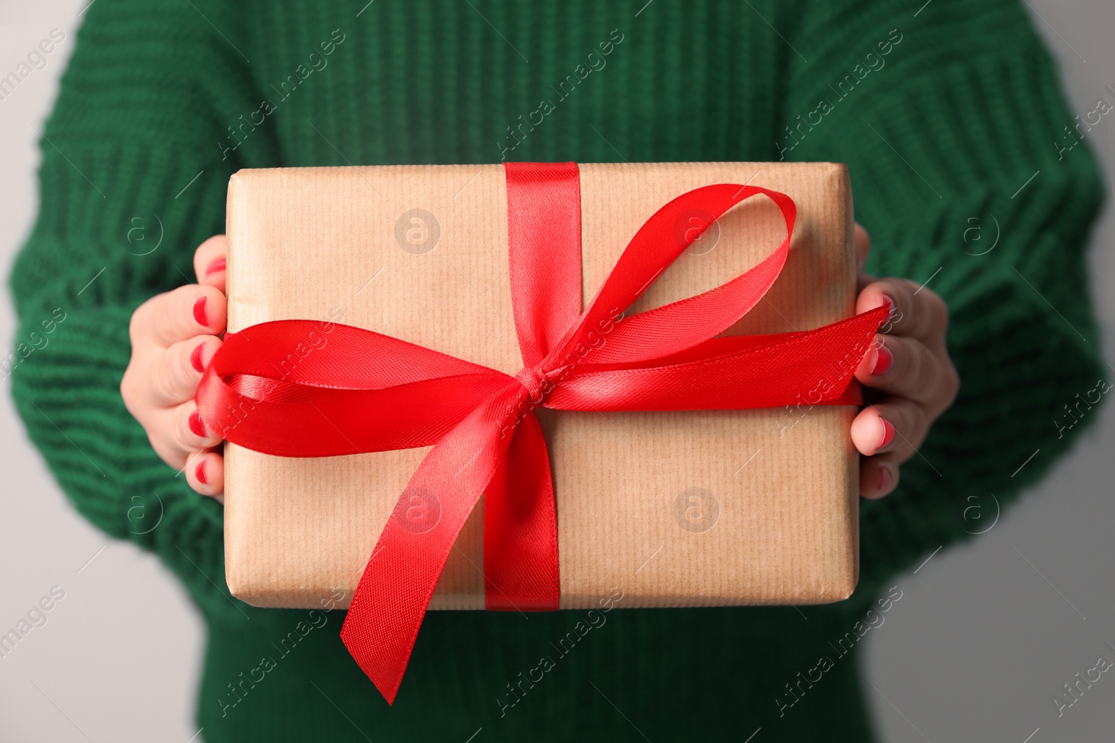 Photo of Christmas present. Woman holding gift box, closeup