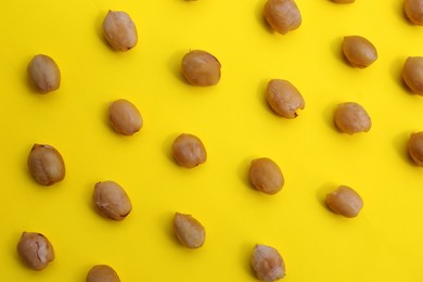 Photo of Tasty organic hazelnuts on yellow background, flat lay