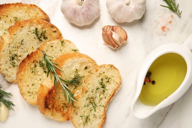 Tasty baguette with garlic, dill, rosemary and oil on table, flat lay