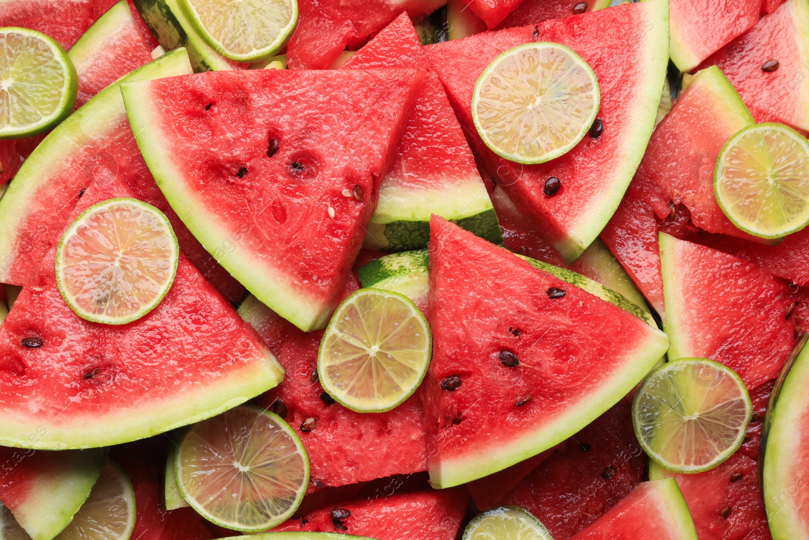 Photo of Slices of juicy watermelon with lime as background, top view