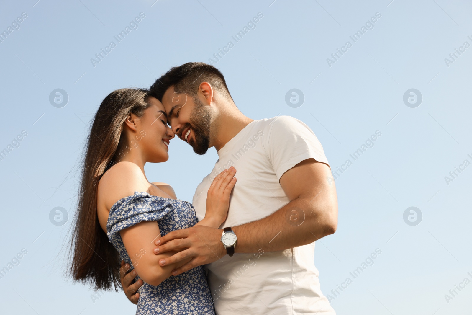 Photo of Romantic date. Beautiful couple spending time together against blue sky, low angle view with space for text