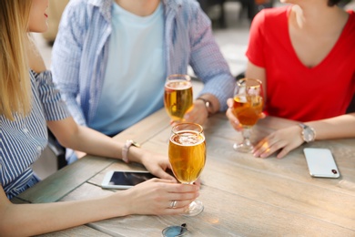 Young people with glasses of cold beer at table