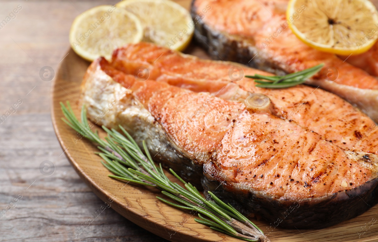 Photo of Tasty cooked red fish on wooden table, closeup