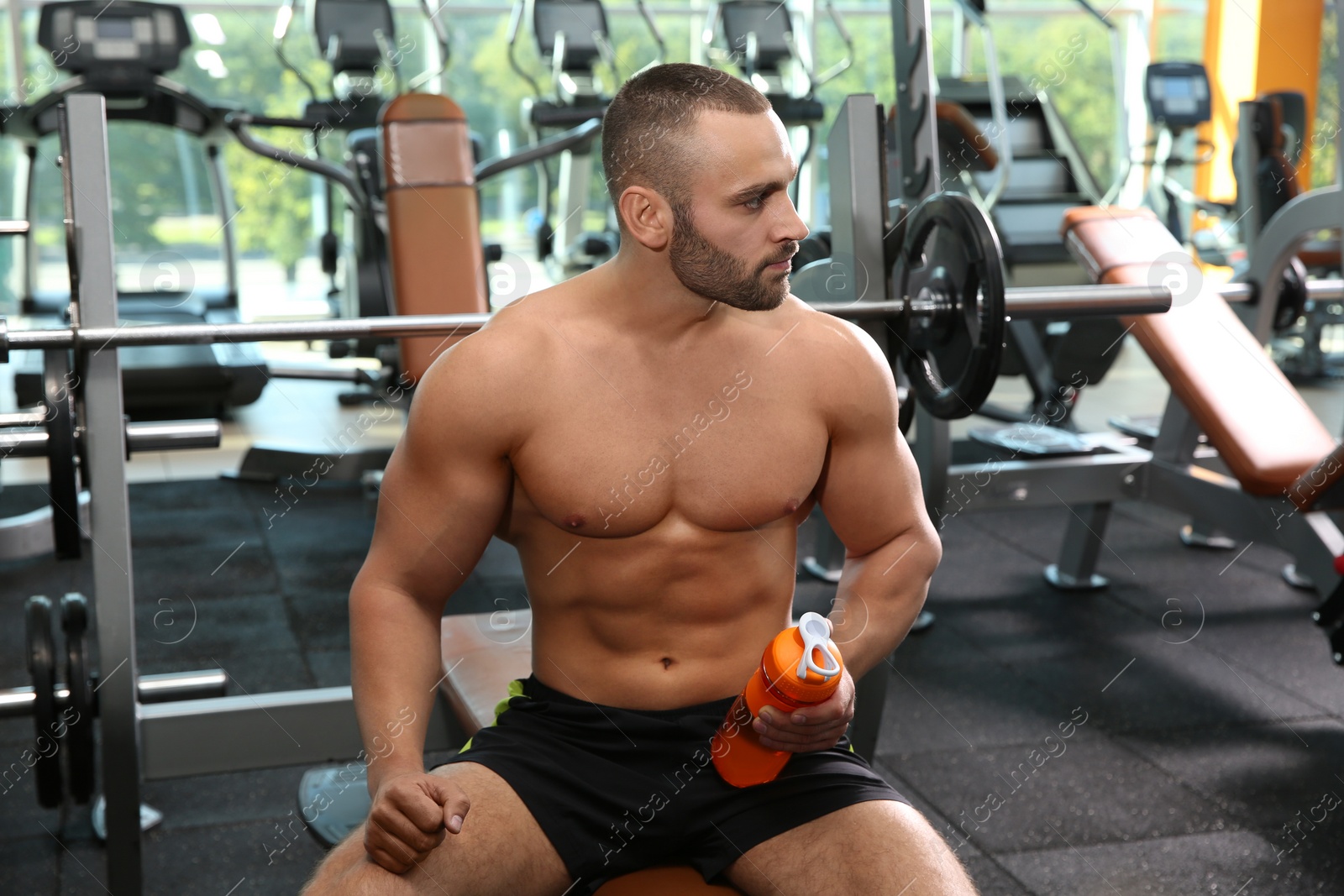 Photo of Portrait of athletic man with protein shake in gym