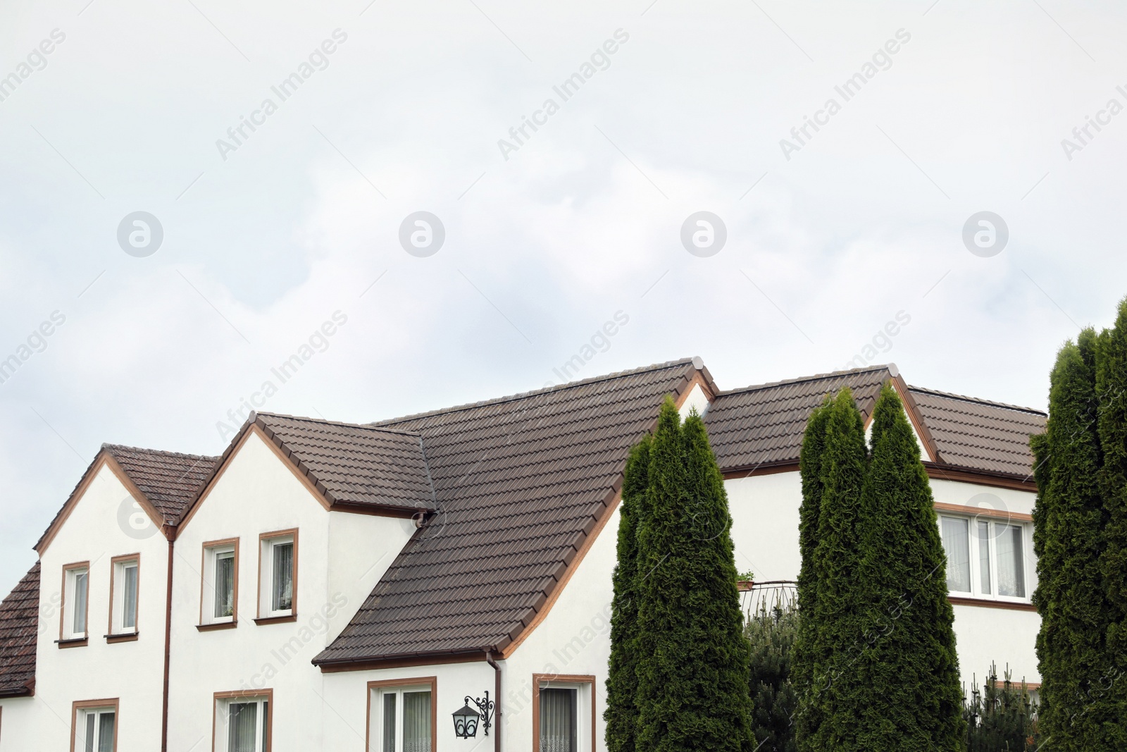 Photo of Beautiful house with brown roof against blue sky