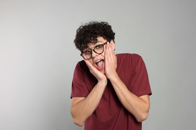 Photo of Portrait of shocked young man on light grey background