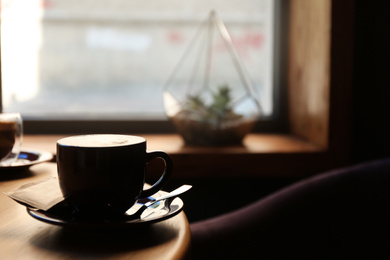 Photo of Aromatic coffee on wooden table in cafe. Space for text