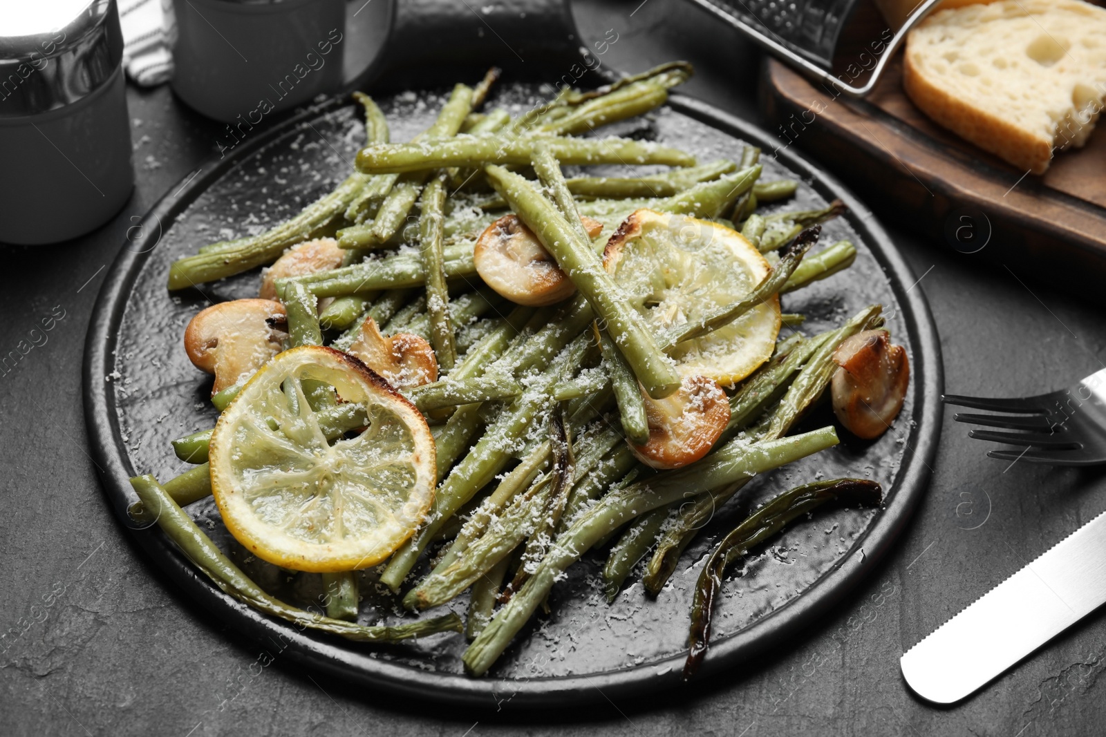 Photo of Delicious baked green beans served on black table