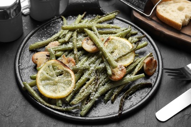 Photo of Delicious baked green beans served on black table