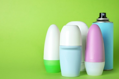 Set of different deodorants on light green background