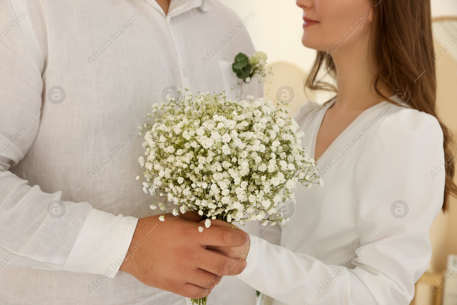 Photo of Bride and groom together indoors, closeup. Wedding couple