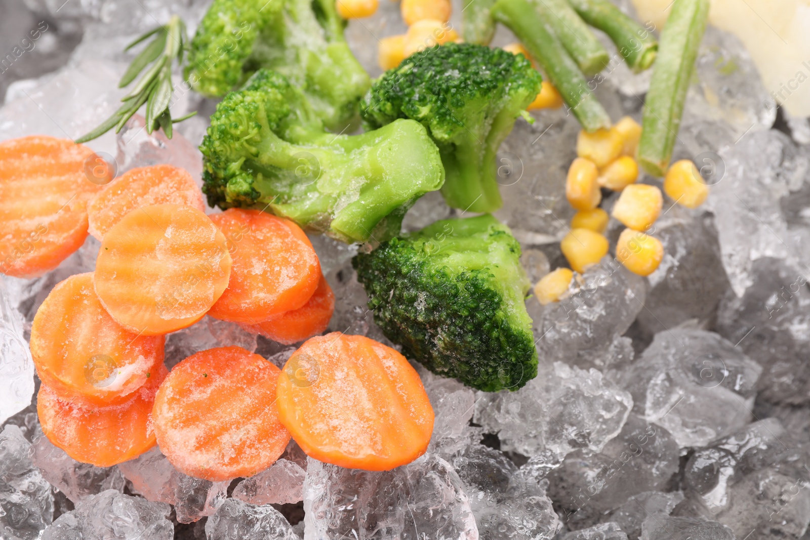 Photo of Different frozen vegetables on ice, flat lay