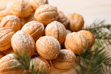 Delicious nut shaped cookies and fir tree branches on table, closeup