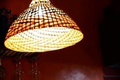 Photo of Hanging lamp wicker shade indoors, closeup. Space for text