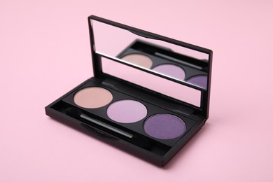 Beautiful eye shadow palette and brush on pink background