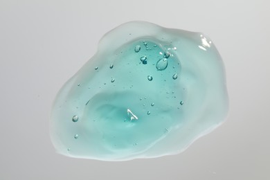 Sample of turquoise facial gel on white background, top view