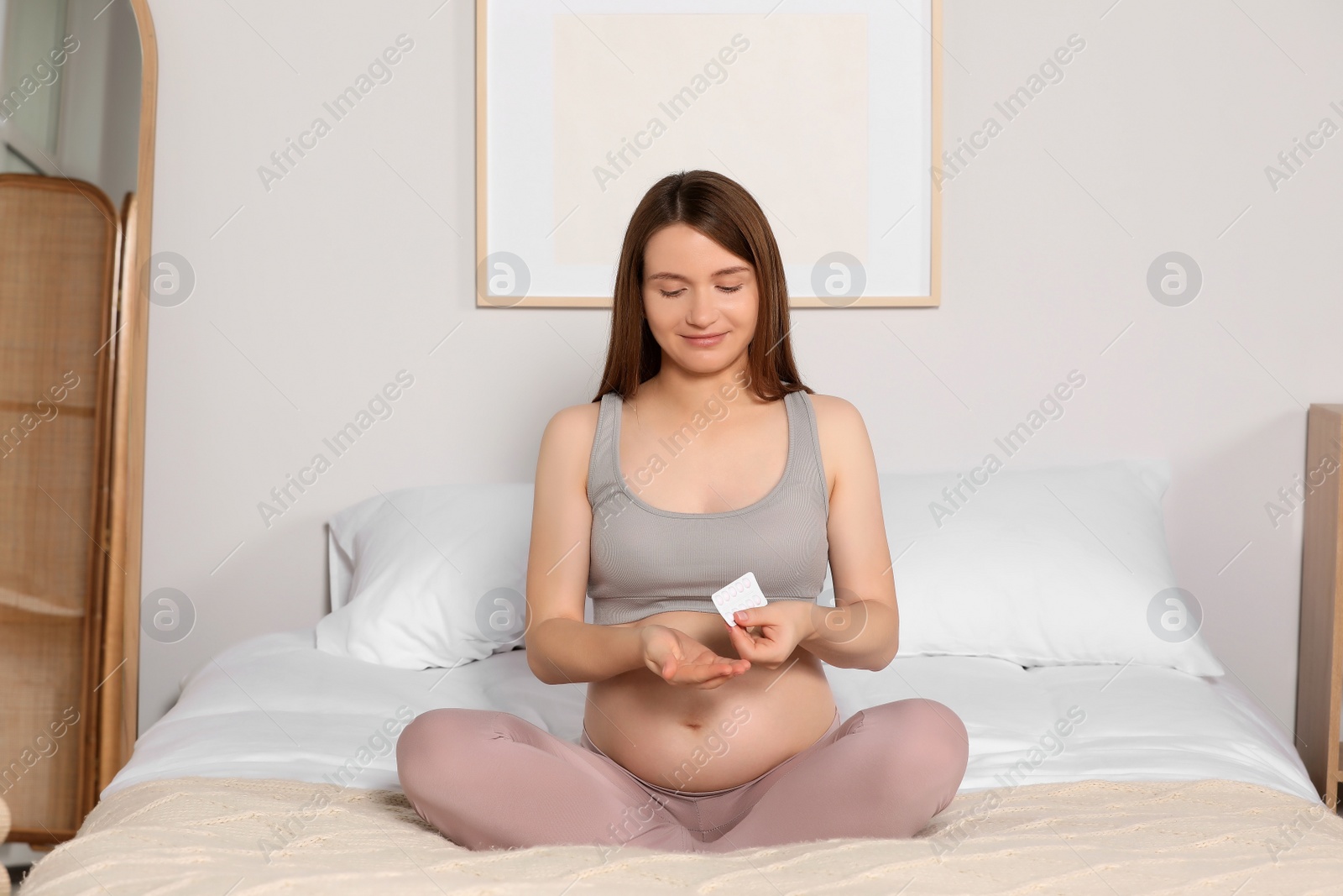 Photo of Beautiful pregnant woman taking pill at home