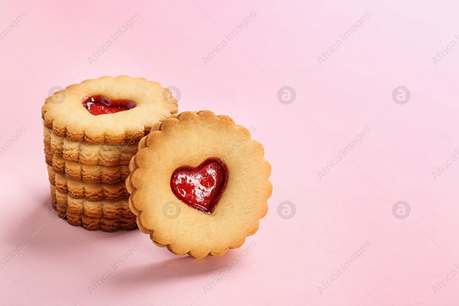 Photo of Traditional Christmas Linzer cookies with sweet jam on color background