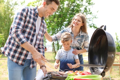 Happy family having barbecue with modern grill outdoors