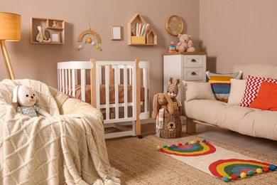 Photo of Baby room interior with stylish furniture and comfortable crib
