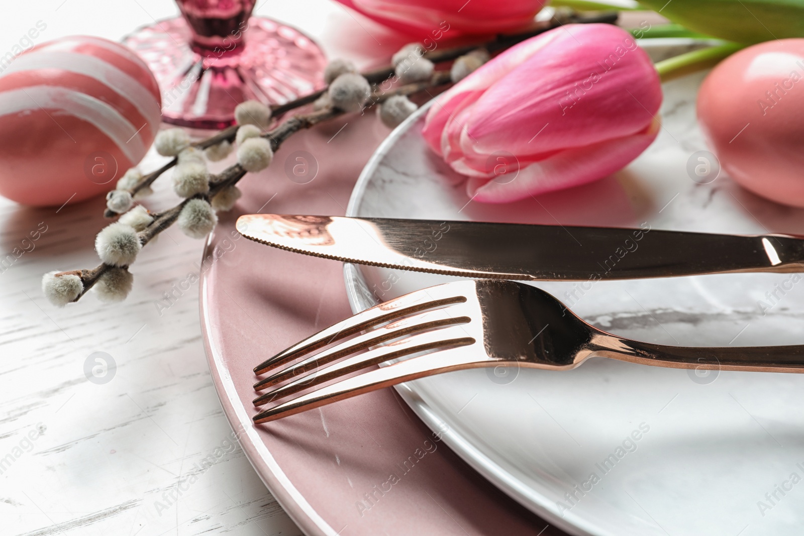 Photo of Festive Easter table setting with painted eggs on wooden background, closeup