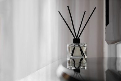 Aromatic reed air freshener on tv table indoors, space for text