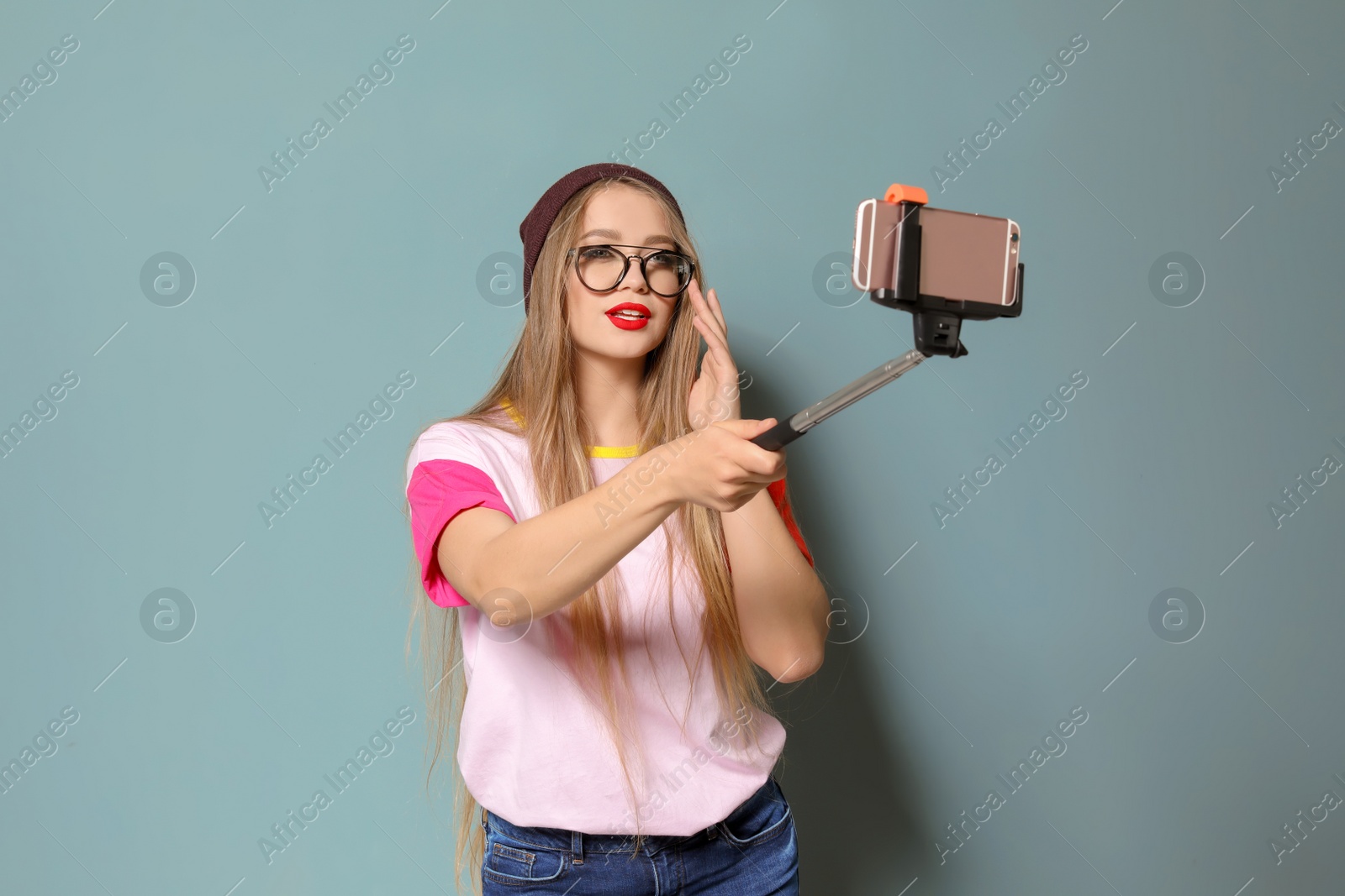 Photo of Attractive young woman taking selfie on grey background