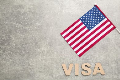 Photo of Word Visa and American flag on light grey table, flat lay. Space for text