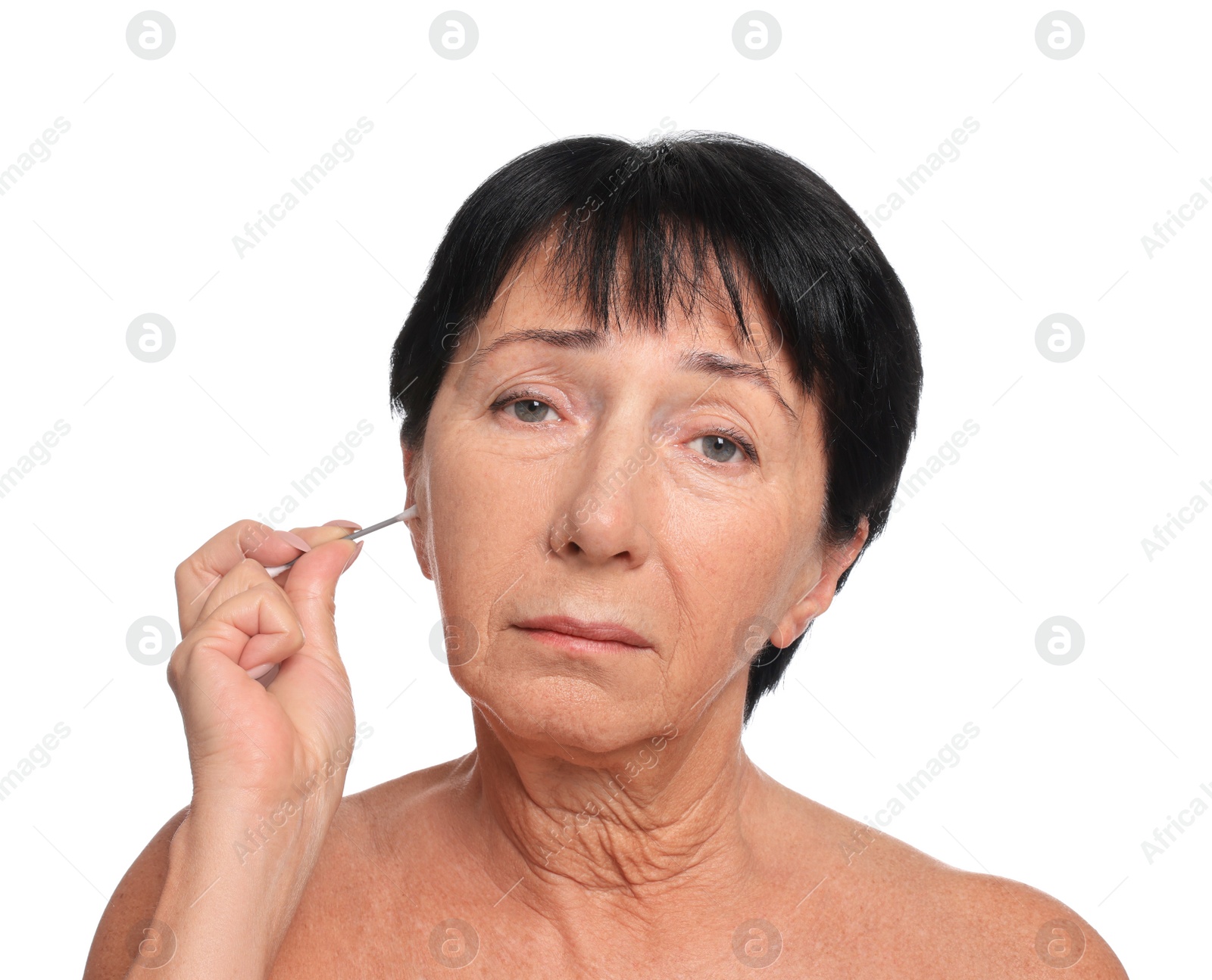 Photo of Senior woman cleaning ear with cotton swab on white background