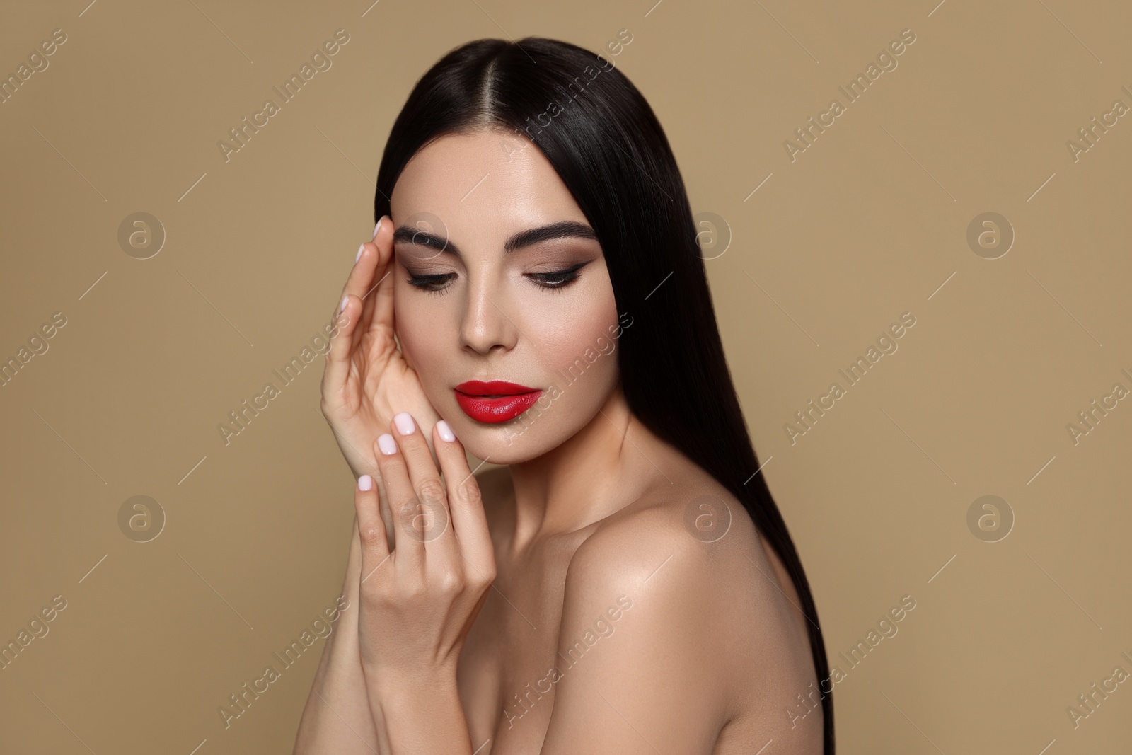 Image of Portrait of young woman wearing beautiful red lipstick on beige background