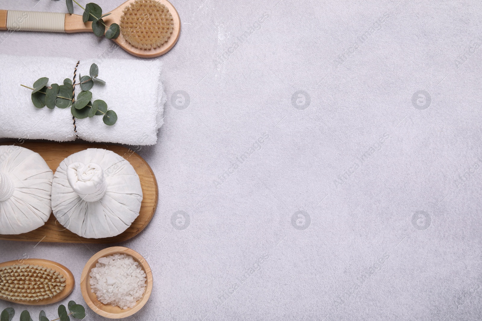 Photo of Flat lay composition with spa products and eucalyptus branches on grey table. Space for text