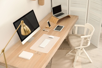 Photo of Stylish workplace interior with modern computer on table. Mockup for design