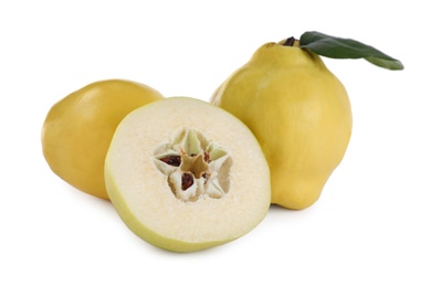 Photo of Whole and cut delicious quinces on white background