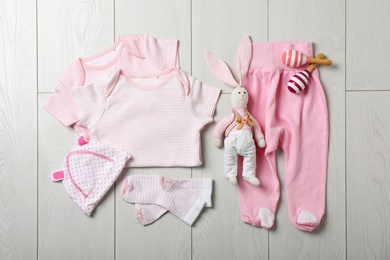 Photo of Flat lay composition with stylish baby clothes on wooden background