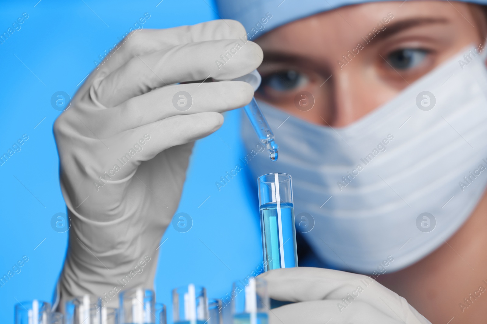 Photo of Scientist dripping reagent into test tube with sample, closeup. Laboratory analysis